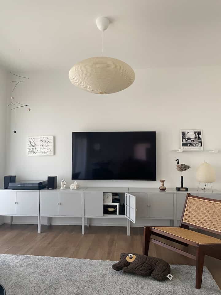 白とナチュラルカラーのリビング、リックスフルトのテレビ台とアカリフロアランプが配置された、シンプルでモダンな雰囲気のインテリア