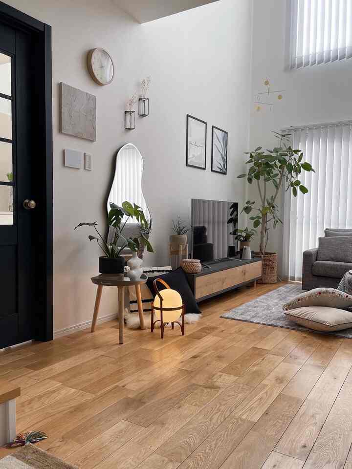 Natural-tone living room featuring gray sofa, wood furniture, and warm lighting creating a cozy bright atmosphere
