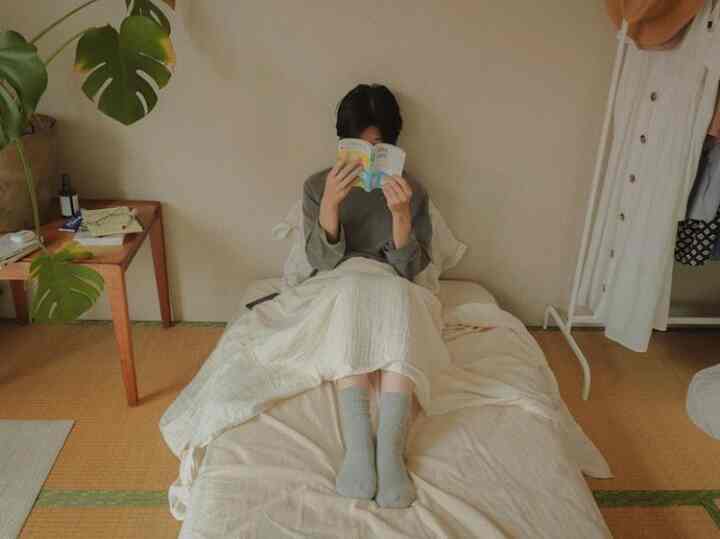 ベージュとナチュラルな色合いの一人暮らし用寝室、低い天井とシンプルな家具が配置された落ち着いた空間