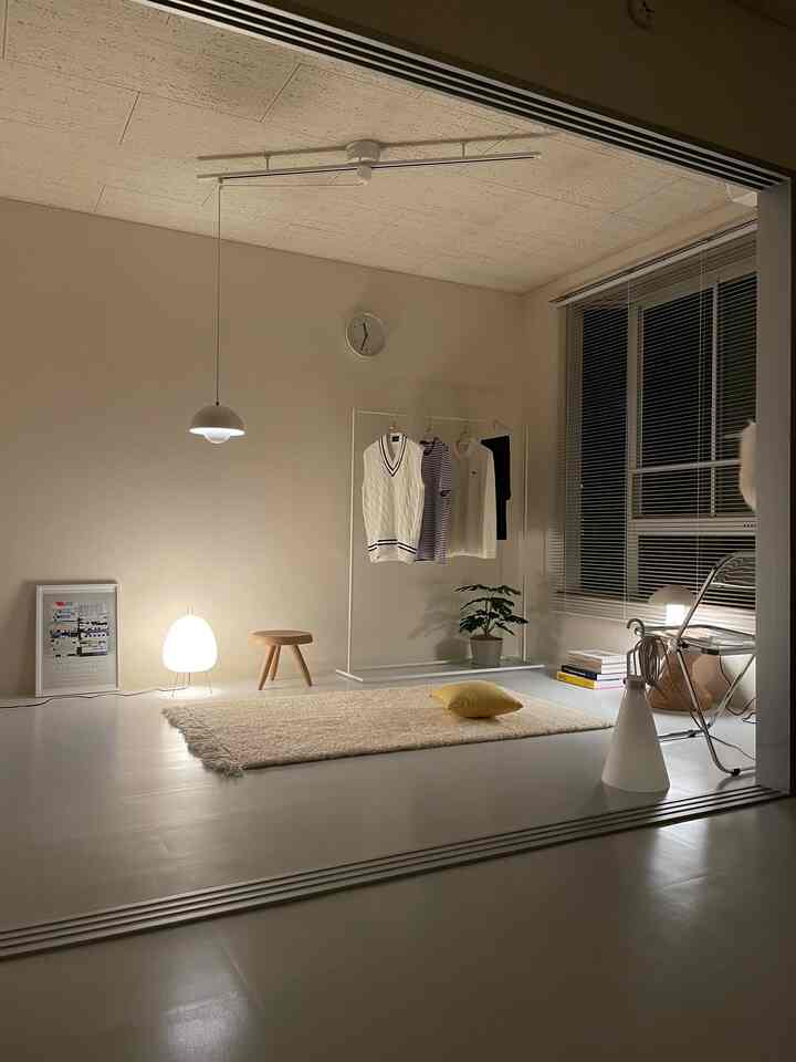 Warm ivory-toned living room and walk-in closet area with simple furniture and cozy lighting creating a clean and tranquil atmosphere