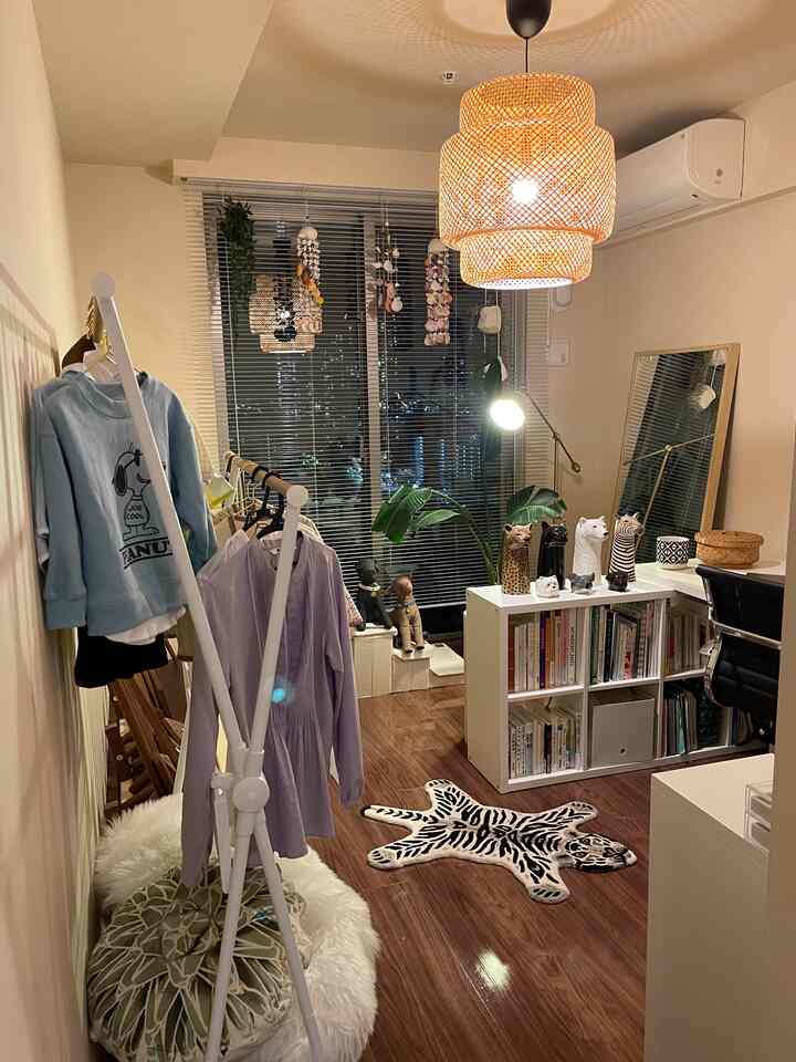 Natural modern home office with wood tone flooring, white furniture, and rattan pendant lighting