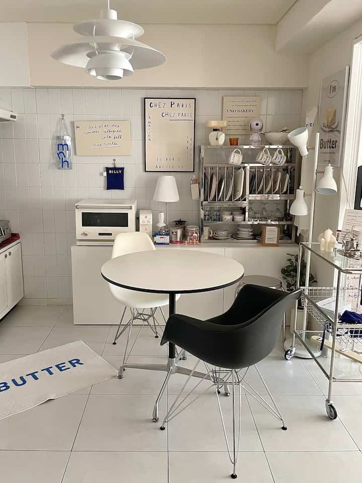 白と黒のトーンが特徴の二人暮らしのダイニング、ラウンドテーブルとイームズチェアが配置されたモダンでナチュラルな印象的な空間