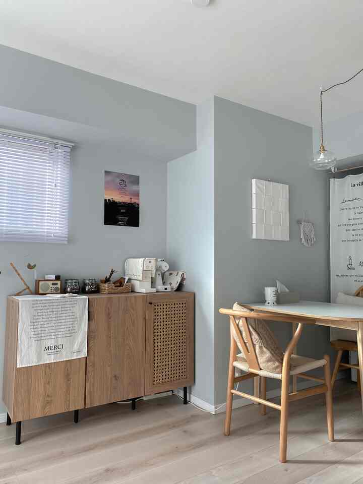 パステルブルーの壁と木目調家具が配置されたシンプルでナチュラルなダイニングルームの雰囲気のあるインテリア