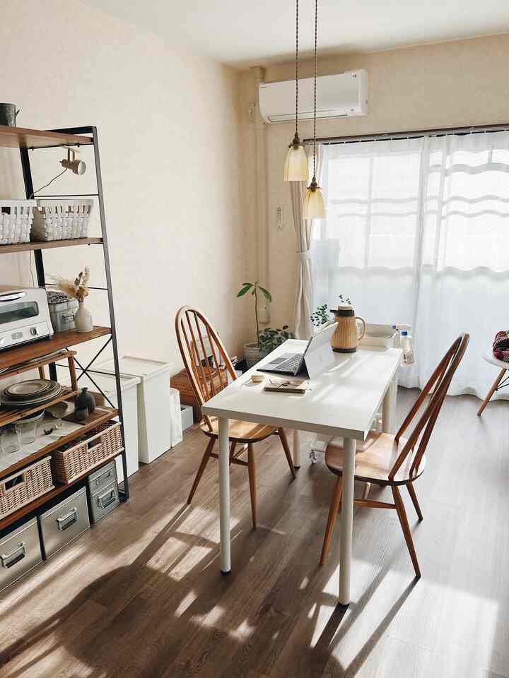 Bright beige and brown toned living room featuring a white dining table with wooden chairs in a natural modern interior