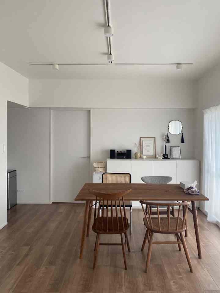 白と木目調が調和したシンプルな4人用ダイニングルーム、自然光が明るく差し込む清潔感のある空間