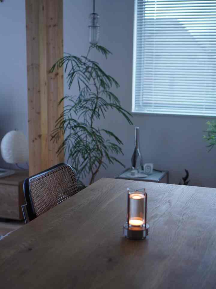 Natural toned living room featuring wooden dining table and blinds, creating a calm and cozy interior