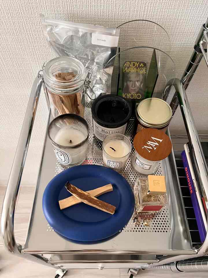 シルバーのキッチンワゴンの上に青い皿と複数のキャンドルが整然と配置されたインテリア