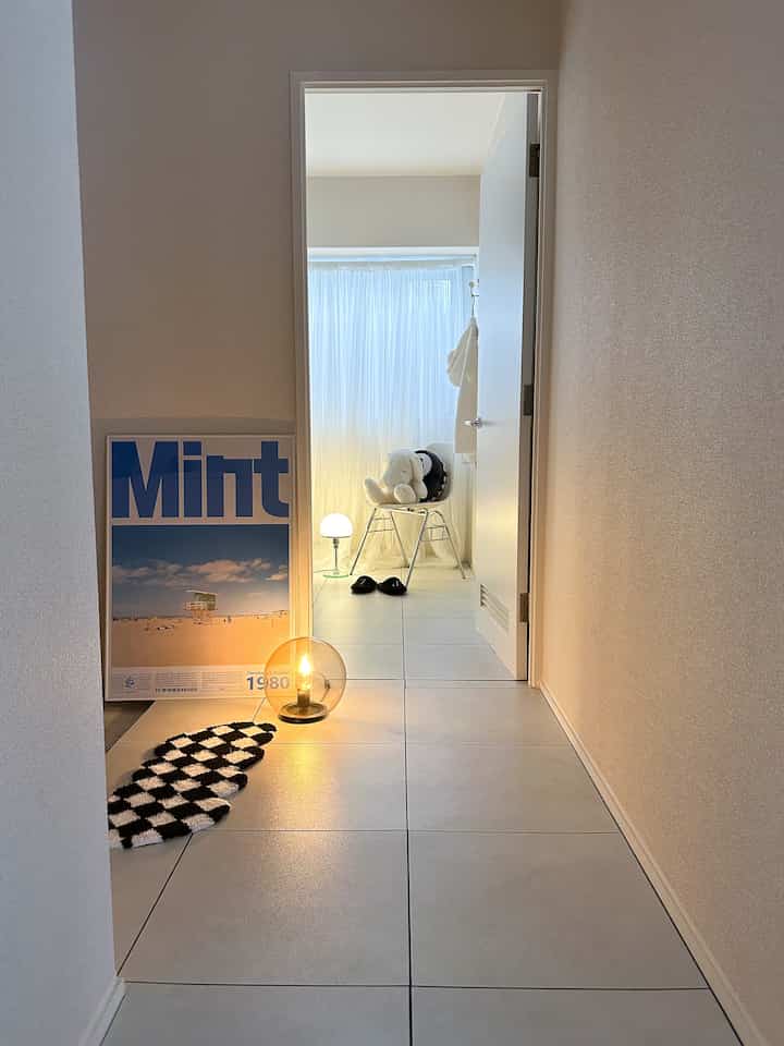 White-toned hallway leading to a room with tiled flooring, spherical lamp, featuring a simple and modern atmosphere