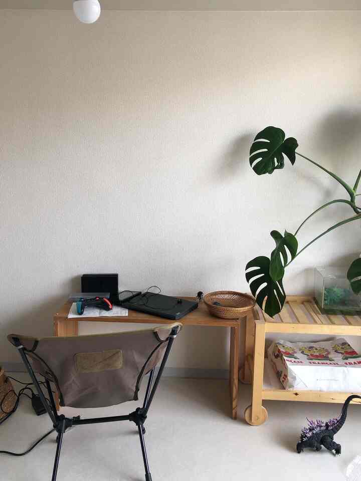 ナチュラルな色調の子供部屋、木製の机と植物が配置された清潔感のあるインテリア