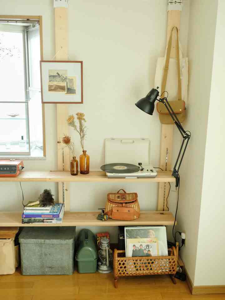 Brown and white toned home office space featuring wooden shelves and vintage accessories with a cozy atmosphere