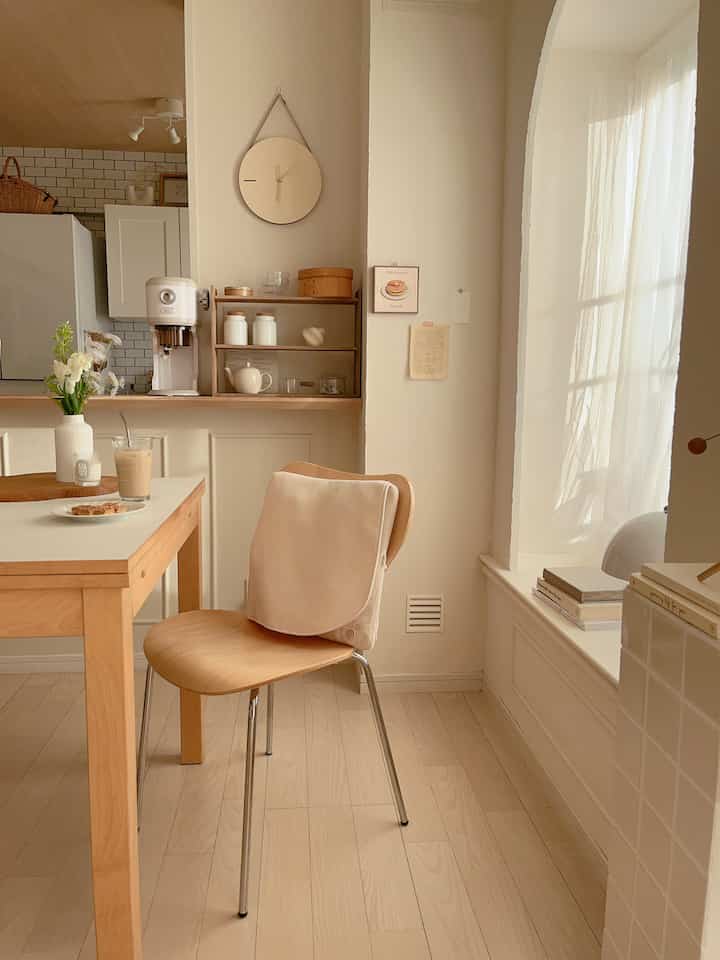 ナチュラルな木目調とホワイトカラーが調和した6畳の寝室、ダイニングテーブルと椅子、マッサージクッションが配置された落ち着いた空間