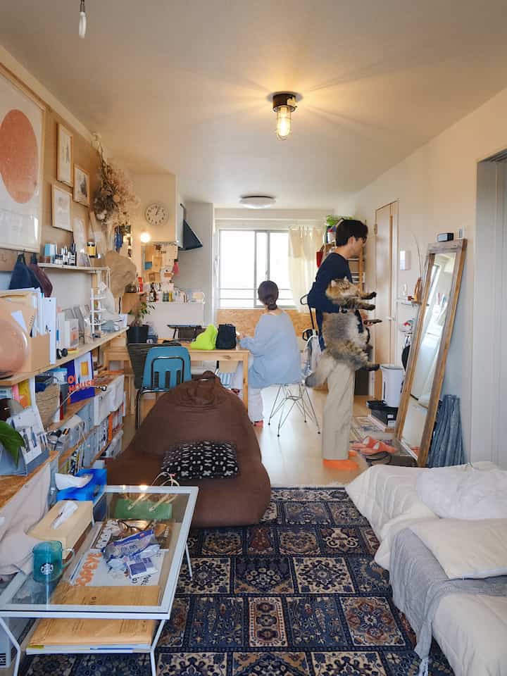 ナチュラルな木目調とブルーのラグが特徴の4人家族向けリビング、猫と共にくつろげる実用的な空間