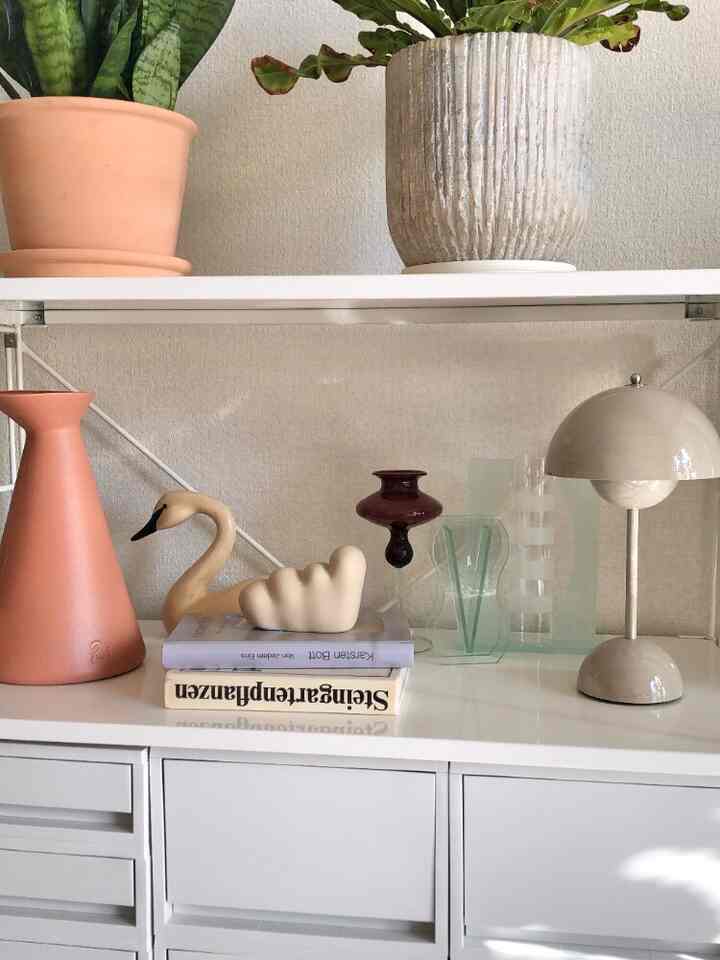 White and beige toned living room featuring mid-century modern objects and plants with a natural atmosphere