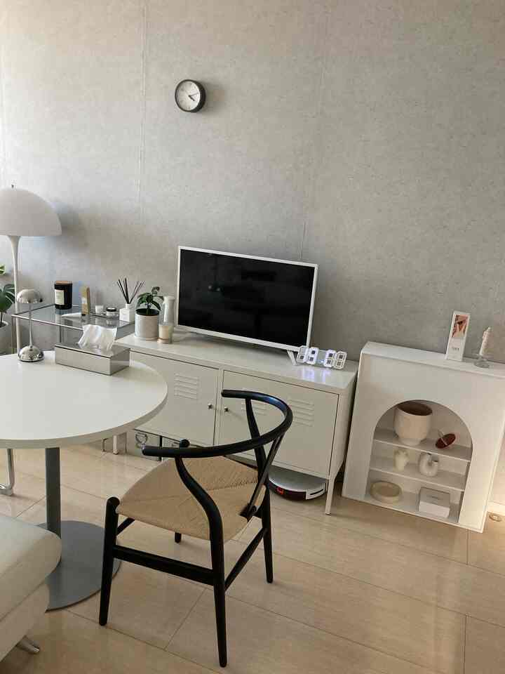 ホワイトとブラックの落ち着いたダイニング、白いキャビネットにテレビ、黒いダイニングチェアが配置されたモダンなインテリア