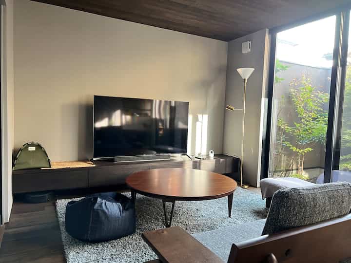 Wood tone and gray living room featuring round coffee table, sofa, and floor lamp in a cozy setting