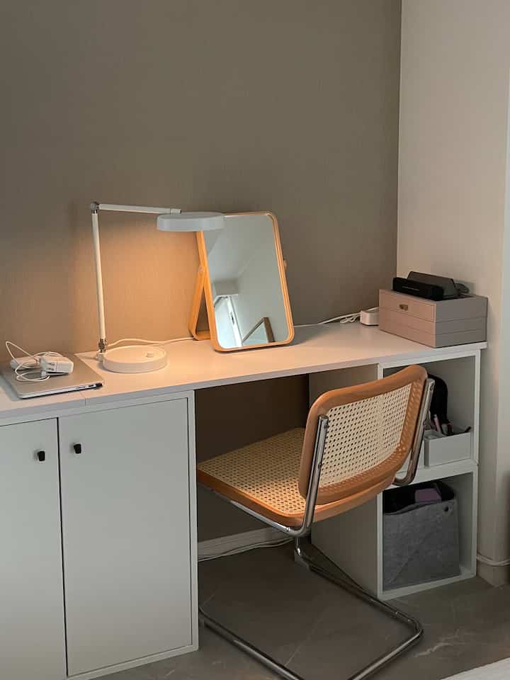 白とナチュラルカラーのウォークインクローゼット、化粧台ミラーとチェスカチェアが配置された印象的な空間