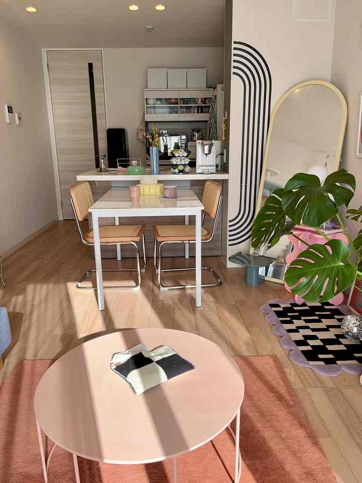 ナチュラルな木目調とピンク色が調和したコンパクトなキッチンとダイニングの雰囲気のあるインテリア