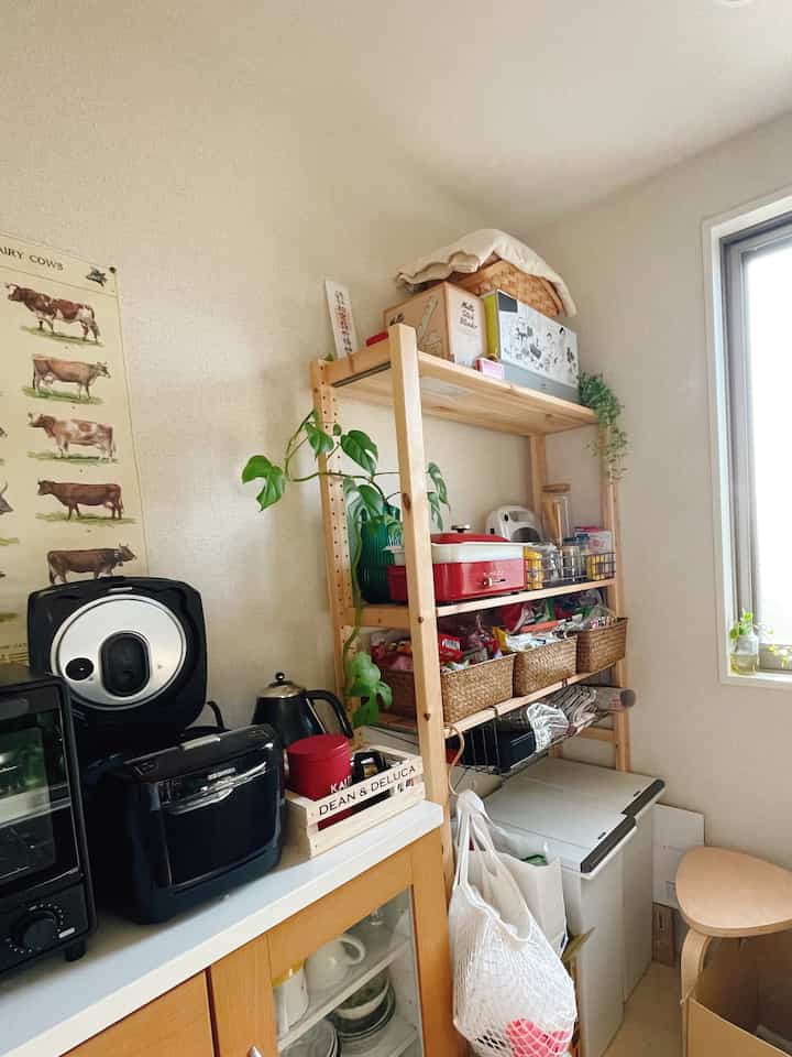 Natural wood-toned small kitchen space featuring IVAR shelving unit and kitchen appliances organized for cozy storage focus