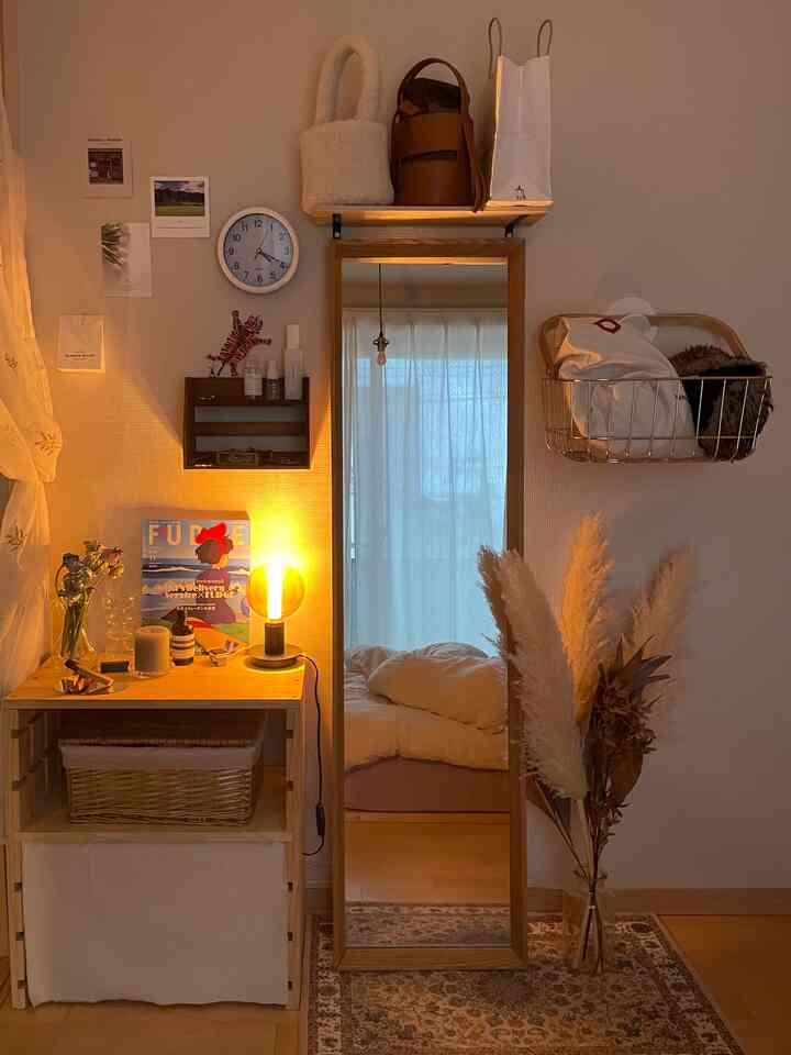 暖かいベージュ調の小さな部屋、大きな鏡と木製の収納が配置された居心地の良い空間