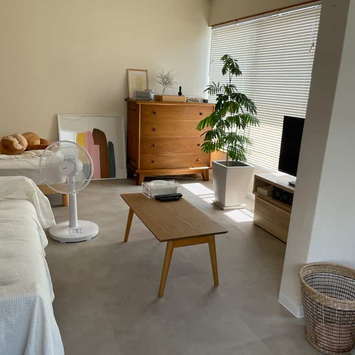 ナチュラルな色調のリビング、木製家具とホワイトベースが調和したミニマルで整った空間