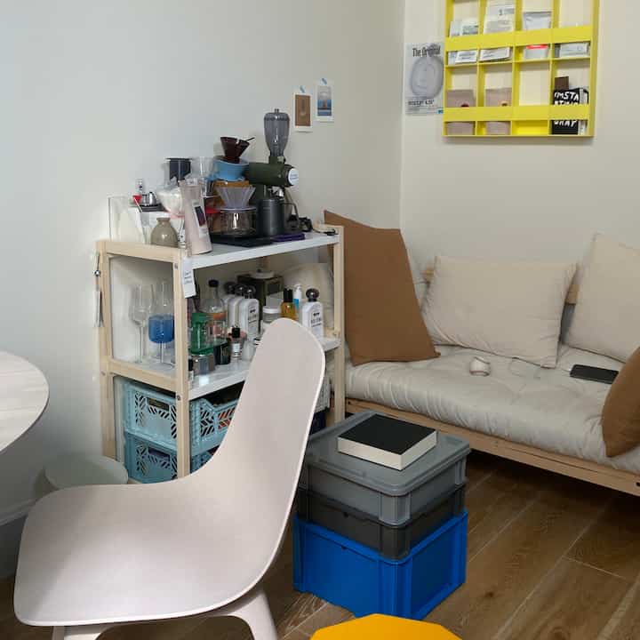 ナチュラルな色調の小さなリビング、ベージュのソファとおうちカフェのアイテムが配置された雰囲気のあるインテリア