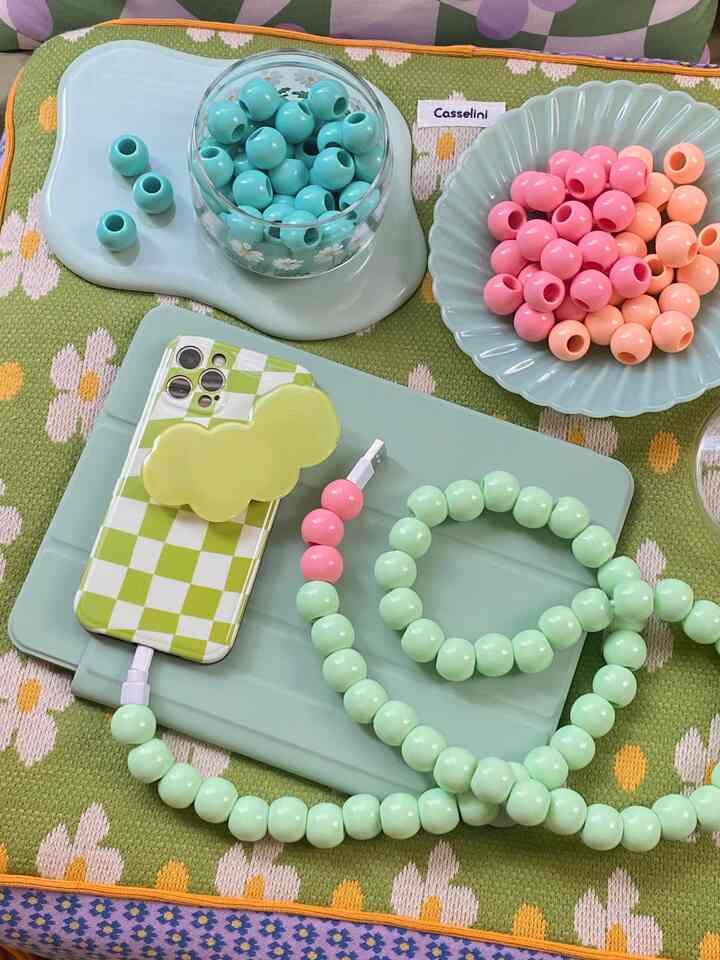 パステルグリーンとピンクのケーブルジュエリーが花柄のカーペットに配置されたかわいいアクセサリー空間