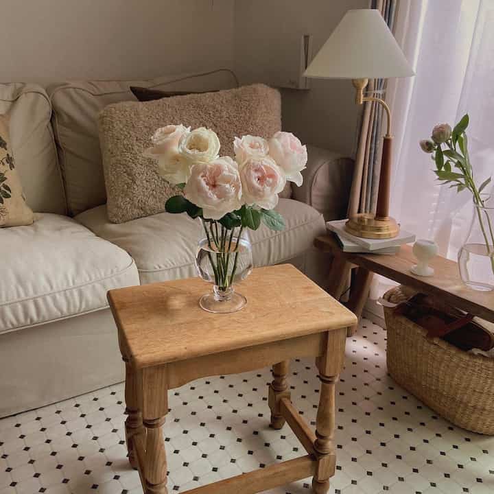 Natural two-seater living room with beige sofa and wood-toned coffee table, featuring bright rose bouquet centerpiece