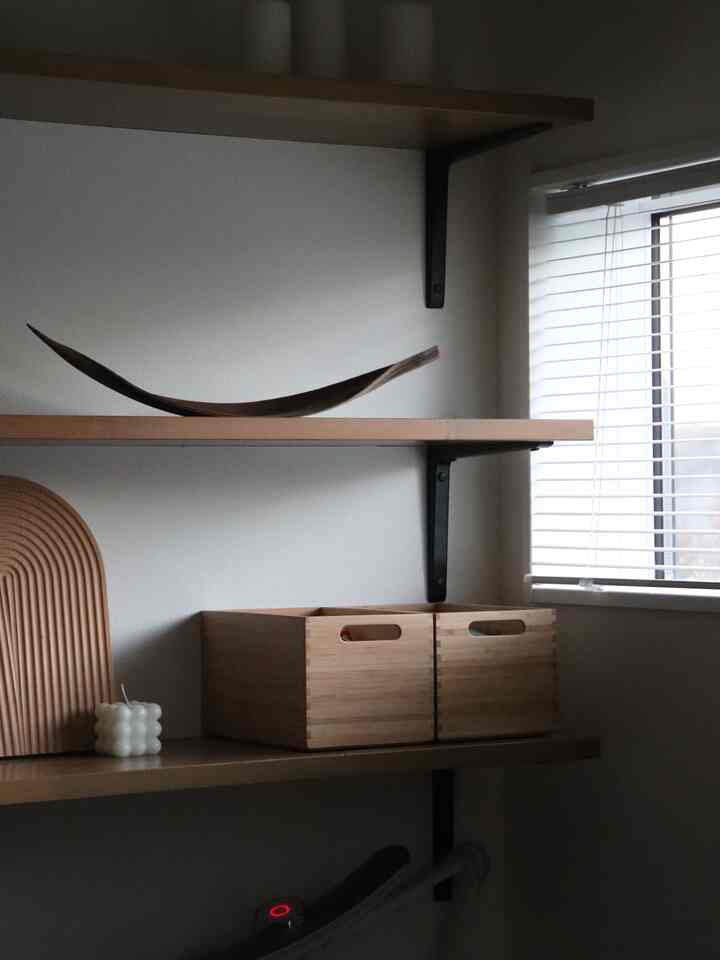 ナチュラルな木目調の棚のある空間、トレイとキャンドルの装飾が落ち着いた雰囲気を演出