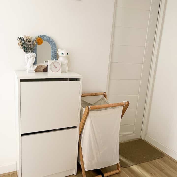 Simple and clean entrance space featuring a white shoe cabinet against white walls