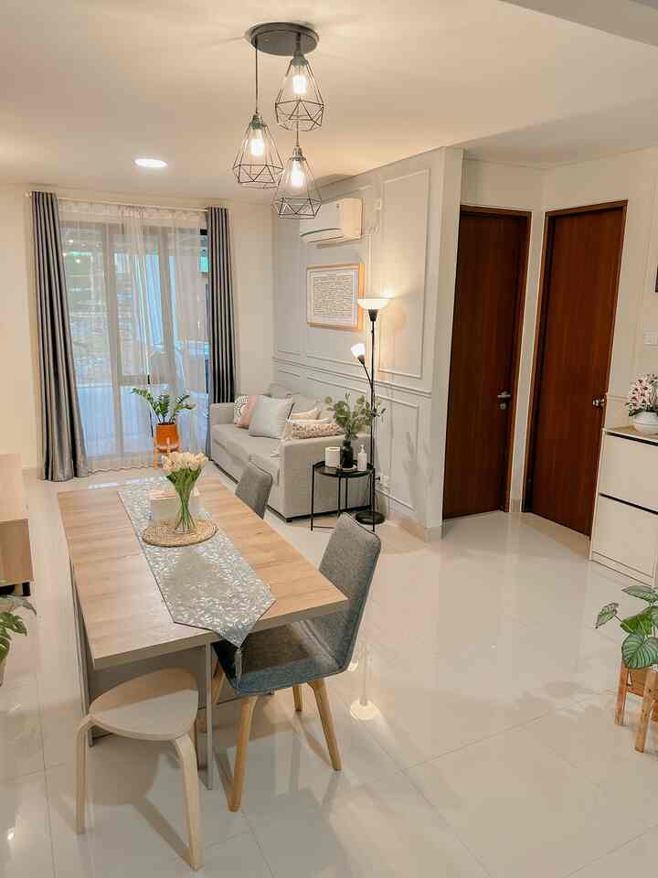 Bright natural modern living and dining room featuring a gray sofa and wooden dining table
