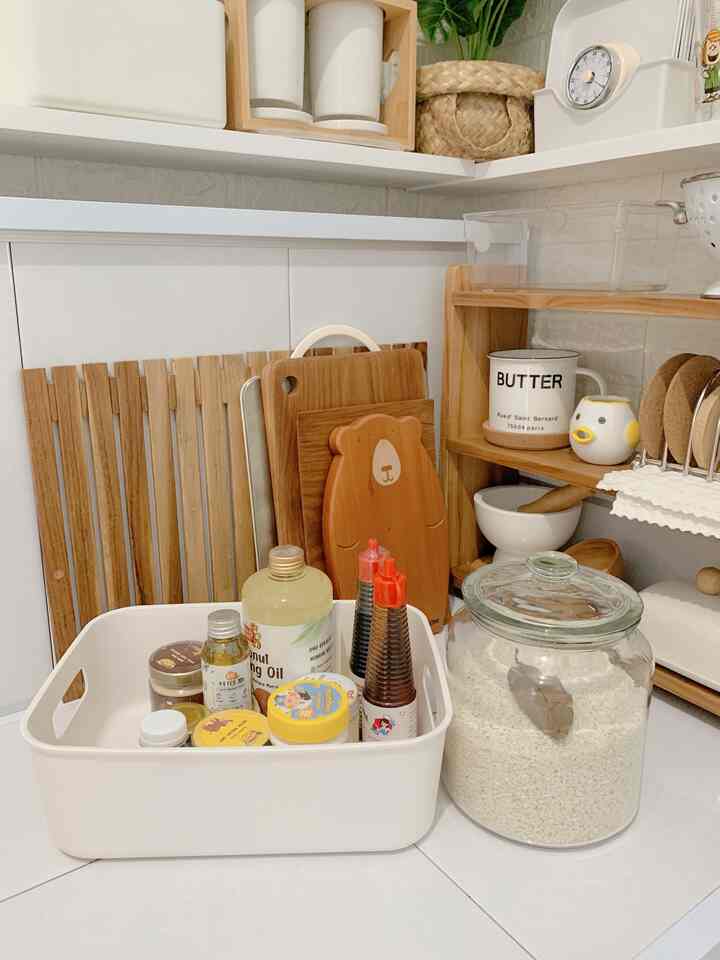 Natural tone kitchen corner with white surfaces, featuring organized kitchen storage items in a cozy setting