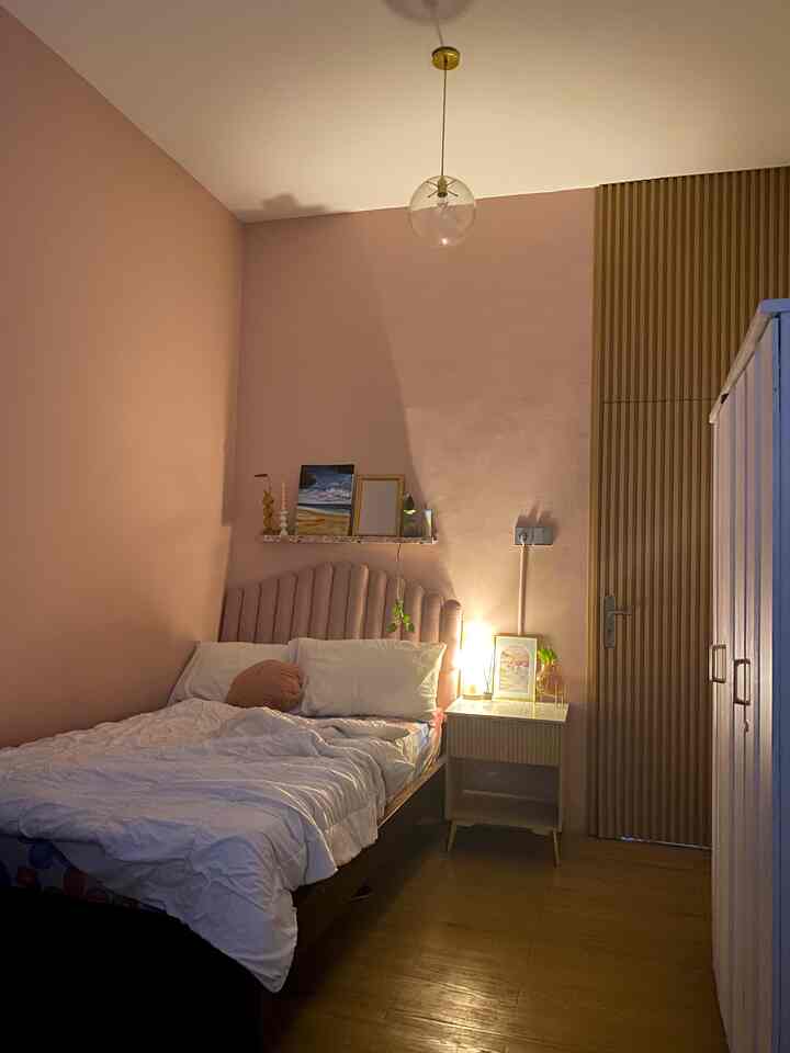 Pink and gold toned bedroom featuring a cupcake-shaped headboard and modern lighting creating an Art Deco atmosphere