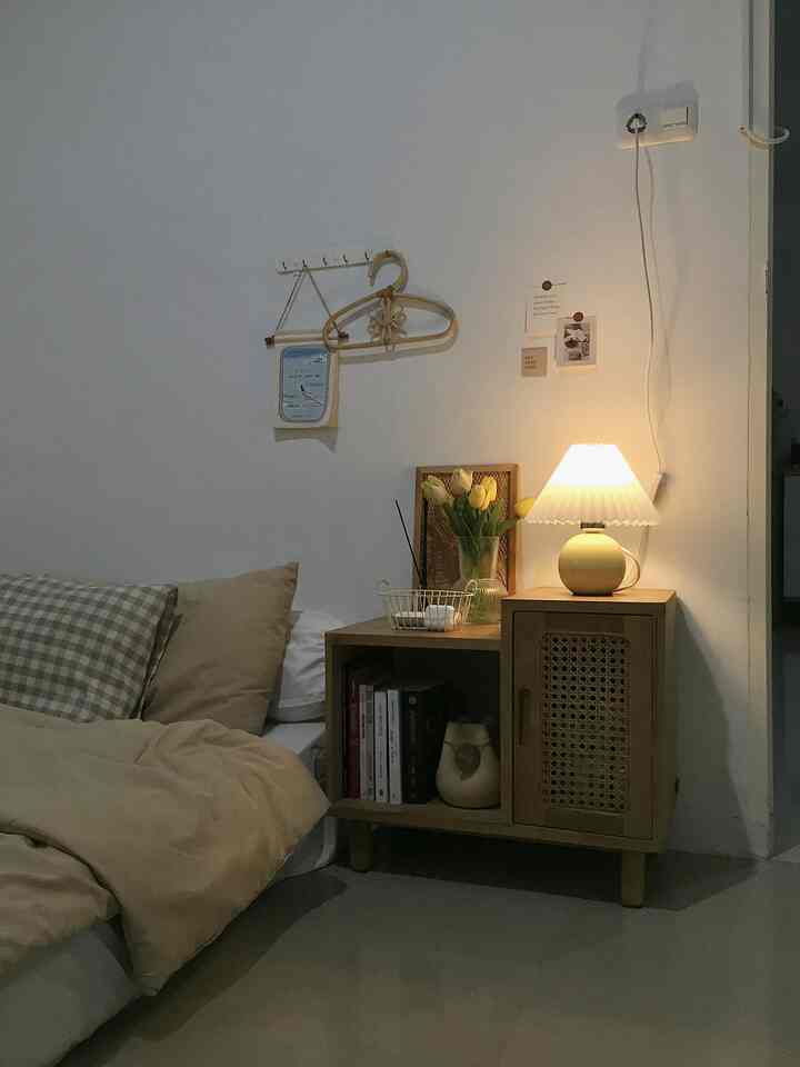 Cozy bedroom with warm beige bedding and softly glowing table lamp