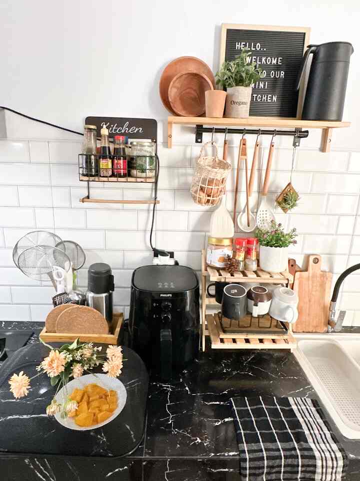 Saat ini belum terpasang kabinet kitchen ataupun ambalan custom pada dapur kami. Jadi kami hanya memadumadankan ambalan yang kami beli di store home decor seperti IKEA & Informa, juga rak kayu 2 tingkat untuk menata gelas dan stok perbumbuan.

Dalam menata dapur mungil kami, diputuskan untuk memakai 3 warna utama (sesuai tema rumah) yaitu warna hitam, putih dan warna kayu. Perintilan dapur yang kami pilih pun menyesuaikan dengan prinsip 3 warna tersebut sehingga tampak padu padan walaupun belum bisa dibilang proper sebagai dapur (karena belum ada kabinet). Selain itu adanya tanaman hidup seperti air plant & tanaman artifisial di dapur ini juga dapat menghidupkan suasana 🪴✨ Alhamdulillah. 

#nyamandiomah #dapurmungil #inspirasidapur #kitchenstyling #kitchendecorideas #kitchenmakeover #kitcheninspo #colorofmyhouse #scandinavian 