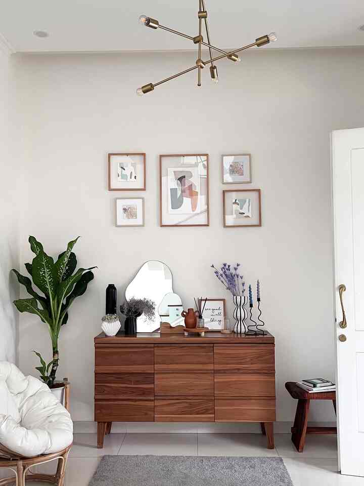 Natural style entrance with white walls and wood tone console table, featuring plants and minimal furniture arrangement