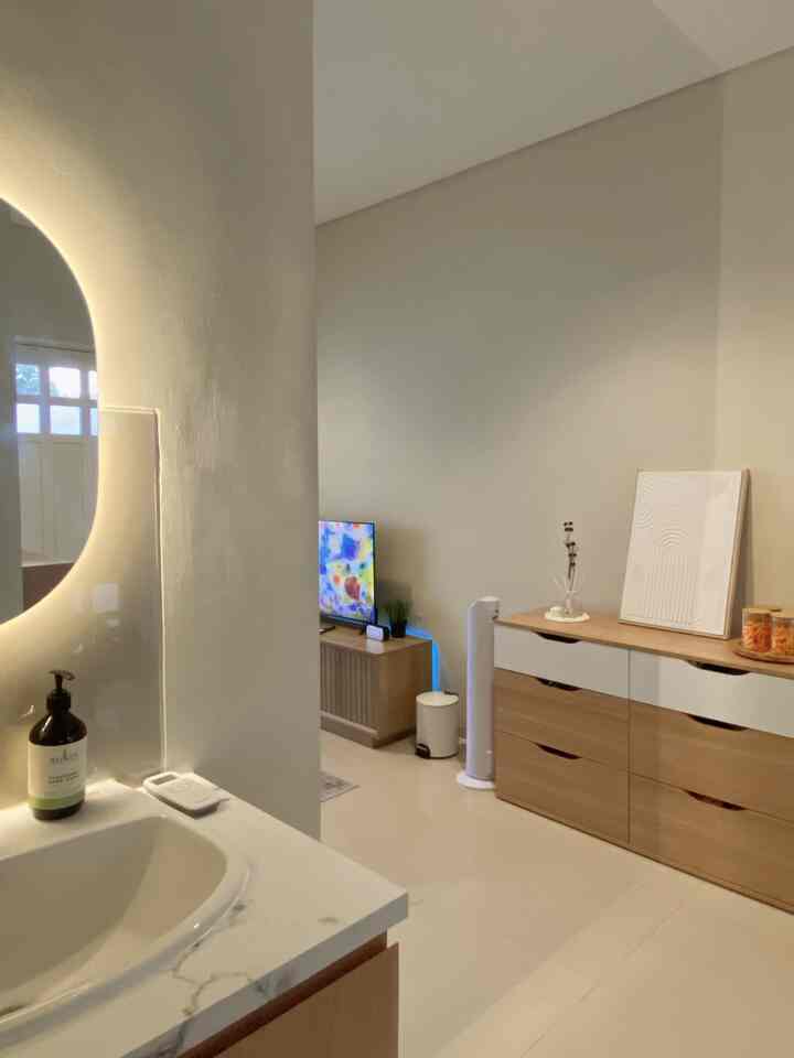 Beige-toned walls with wooden dresser in an open-plan space, featuring bright and clean minimal interior