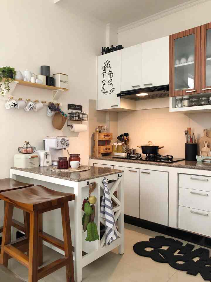 White and wood tone compact kitchen featuring labeled wooden racks and an island dining table with a neat atmosphere