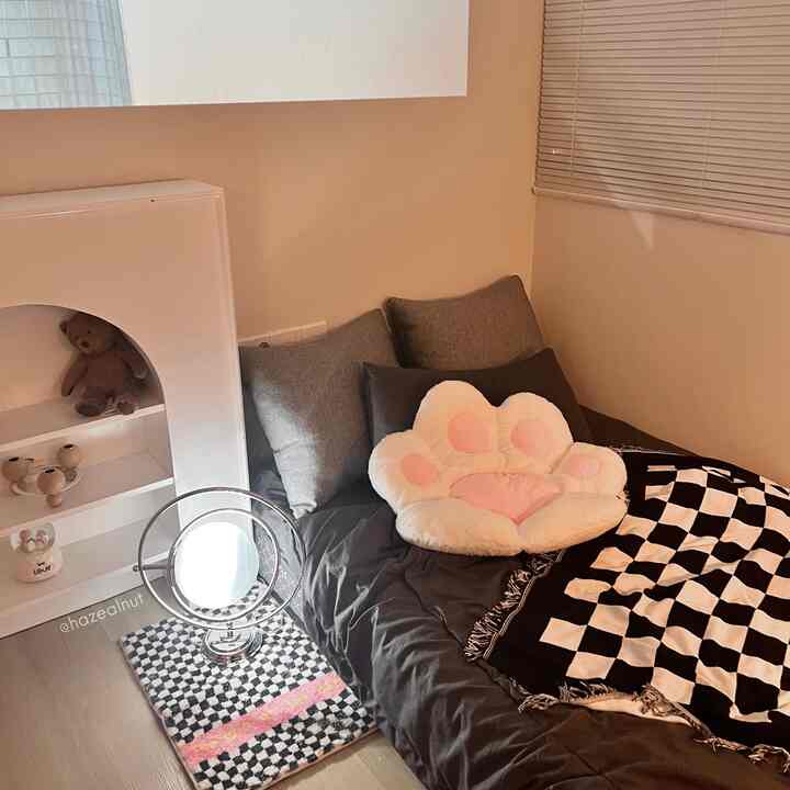 Cozy natural-tone bedroom featuring gray bedding and a cat paw-shaped cushion creating a warm atmosphere