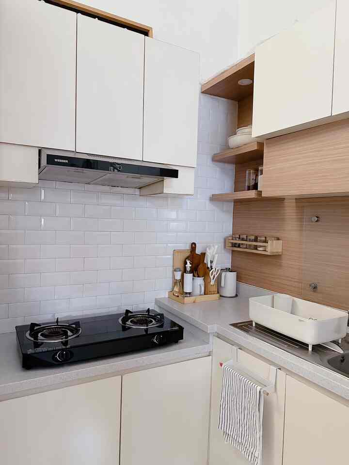 A clean and cozy Scandinavian small kitchen featuring white surfaces and warm wood tones
