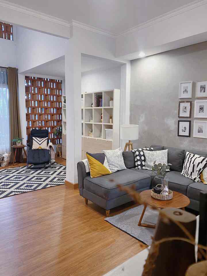 Natural and monotone toned living room featuring large gray sofa, wooden coffee table, and cozy reading corner
