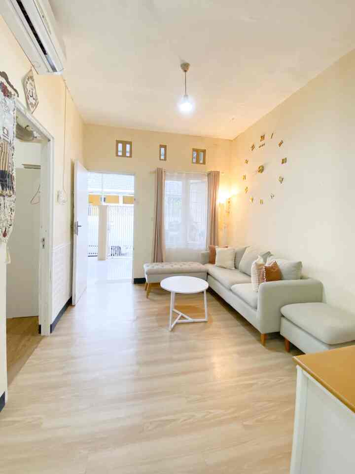 Beige and wood-toned compact living room featuring a simple sofa and round coffee table creating a cozy atmosphere