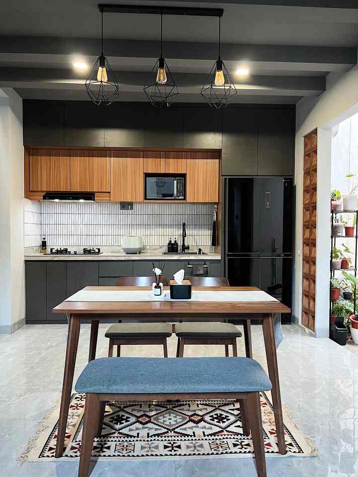 Monotone and wood tone kitchen featuring wooden dining table and bench with industrial ceiling lights, creating a warm atmosphere