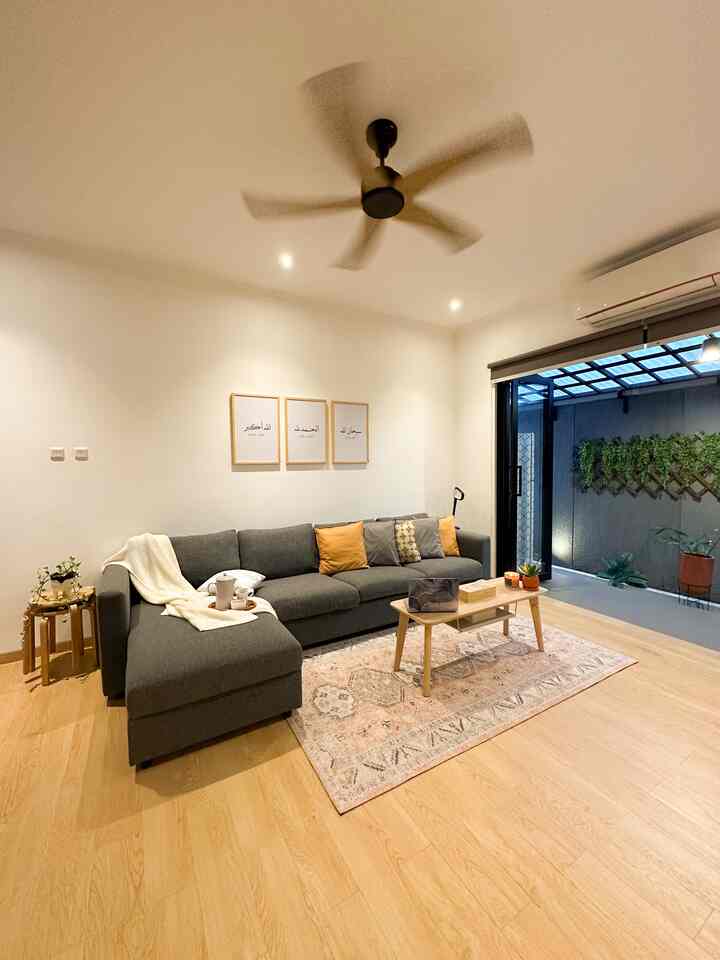 Natural color living room with wood tone flooring and gray sectional sofa, featuring a warm and cozy atmosphere