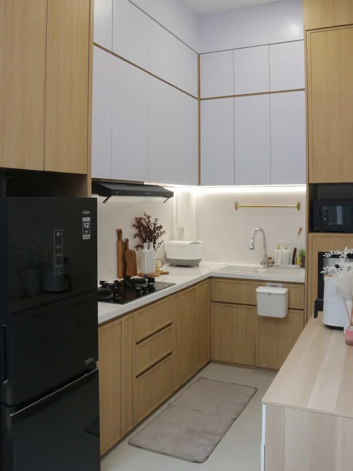 Dapur L ala Japandi di Rumah Eigen
Karena space terbatas di area ini, full kabinet jadi pilihan tepat untuk penyimpanan barang. Area food preparation jadi titik paling favorit bagi kami.

Meskipun full kabinet, supaya dapur kami terlihat lebih estetik ada beberapa item dekorasi yang kami pilih seperti talenan kayu, botol-botol estetik dan bunga si pemanis ruangan.

Seminggu sekali, jangan lupa buka pintu kabinet supaya mereka bernapas dan mengurangi kelembapan. Nah supaya rapi kamu bisa ikut tips dapur rumah eigen dengan:
- pakai kotak organizer untuk stok makanan, dll
- pilih rak multifungsi untuk area bawah sink 
- upgrade botol bumbu jadi seragam dan estetik
- rutin bebersih yaa 😉

#kitchenstyling #kitchendecorideas #kitchenmakeover #japandi #japandikitchen #rumahdeveloper #tangsel #85sqm #dapurL 