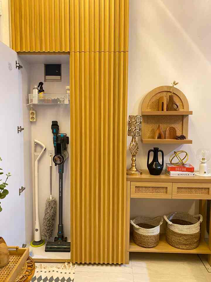 Natural brown toned entrance storage area featuring wooden cabinet and wall shelves with neat decor