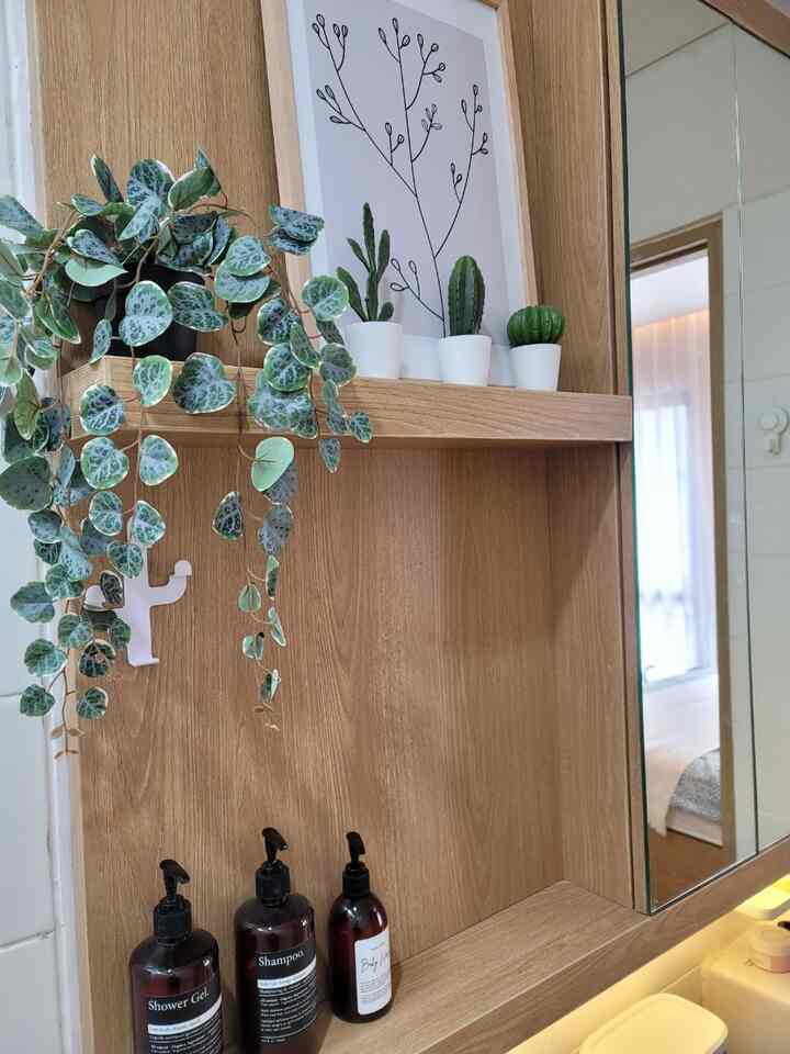 Bathroom with natural color wooden shelves, plants, and a mirror creating a clean and natural atmosphere