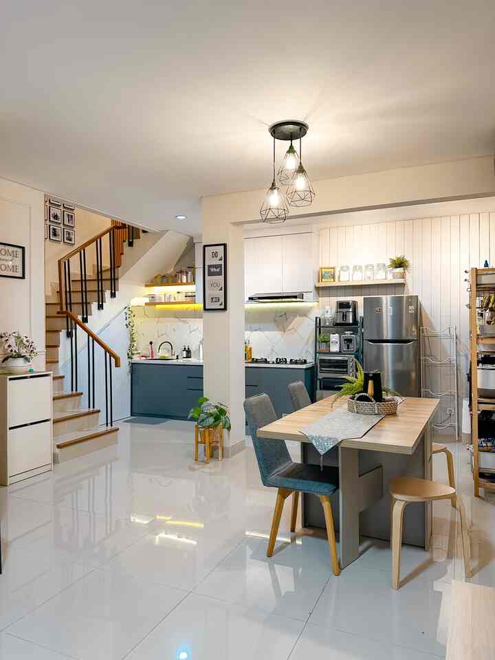 White and natural toned kitchen featuring dining table and pendant lighting in a neat, compact space