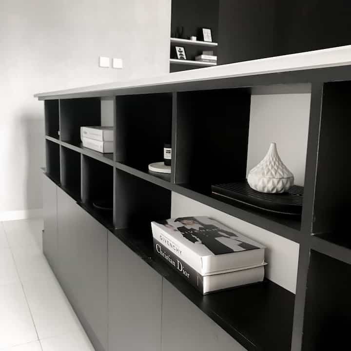 Monotone shelving next to stairs in a minimal and modern space
