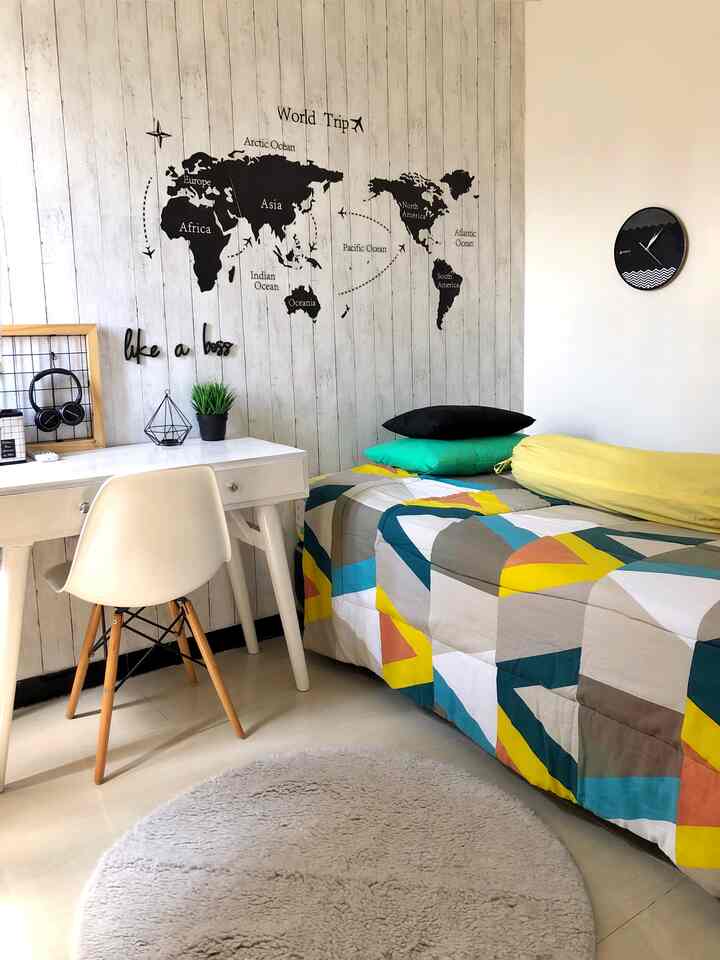 White and gray toned 3m by 3m teen boy's bedroom featuring a clean desk and colorful bedspread in a simple, cozy space