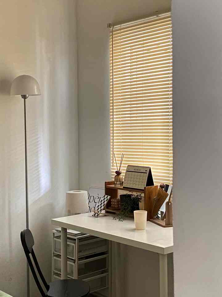 A compact single household reading corner in white and beige tones, featuring a clean desk and storage cabinet with a simple layout